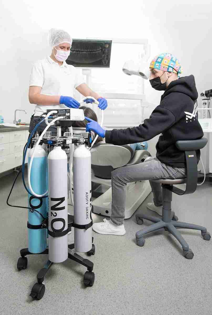 Detailed shot of a dentist applying veneer to a woman's teeth during a dental procedure.