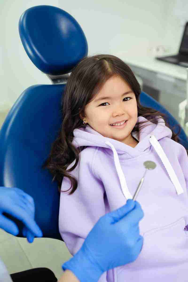 Detailed shot of a dentist applying veneer to a woman's teeth during a dental procedure.